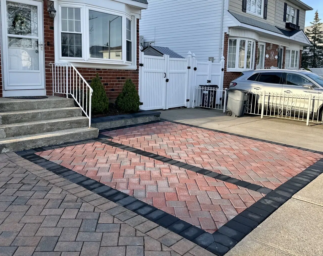 Red herringbone paver driveway bordered in charcoal at brick home — APPLE MASONRY INC in Brooklyn